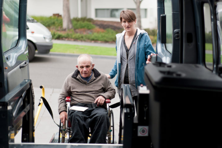 Old man in wheelchair getting into van