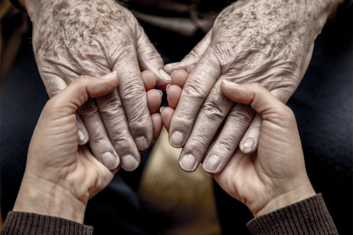 Senior hand grabbing young hand